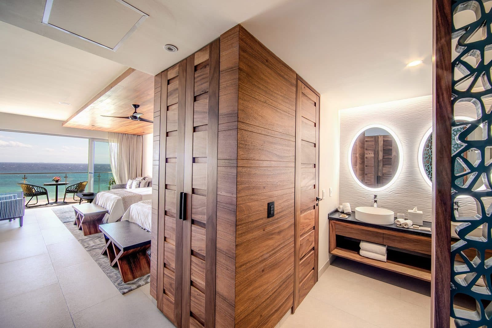 Queen Suite Ocean View: two beds under a wood ceiling, a wood-panelled bathroom vanity, and a balcony with a view of the sea